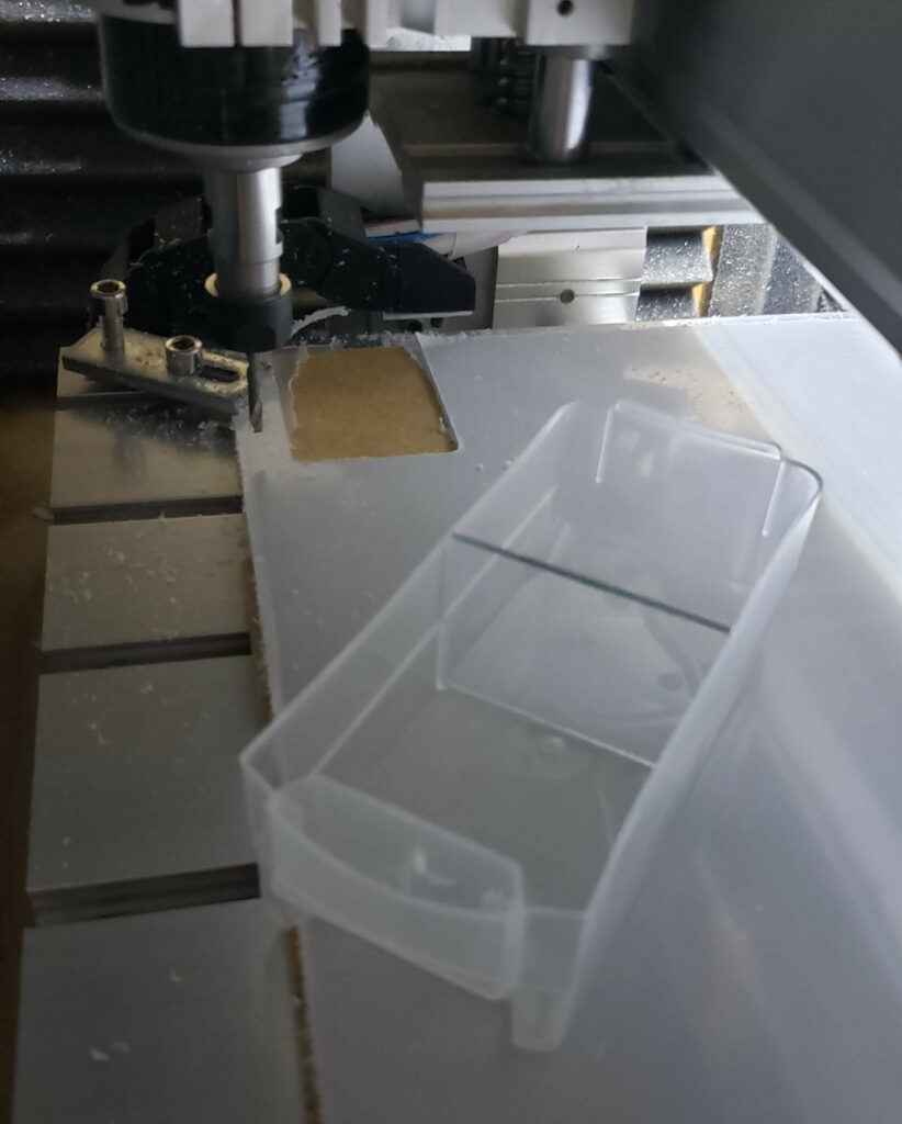 Installed polycarbonate drawer divider, next to the CNC setup it was cut on. 