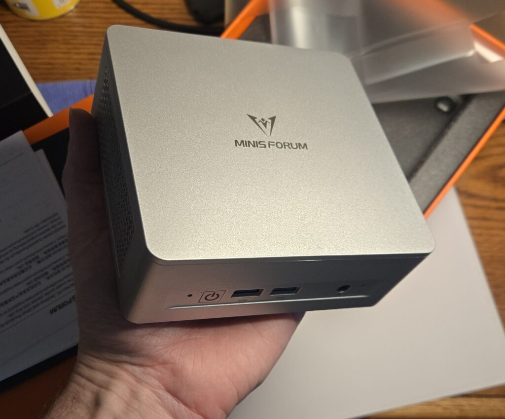 A Minisforum UM870Slim held in-hand to show size.